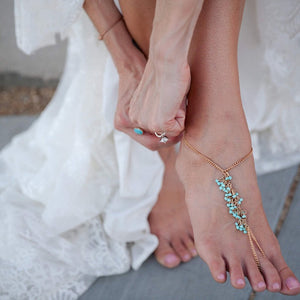 Bride putting on barefoot sandals for ceremony