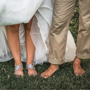 Bride is showing off her bare feet wearing bottomless sandals